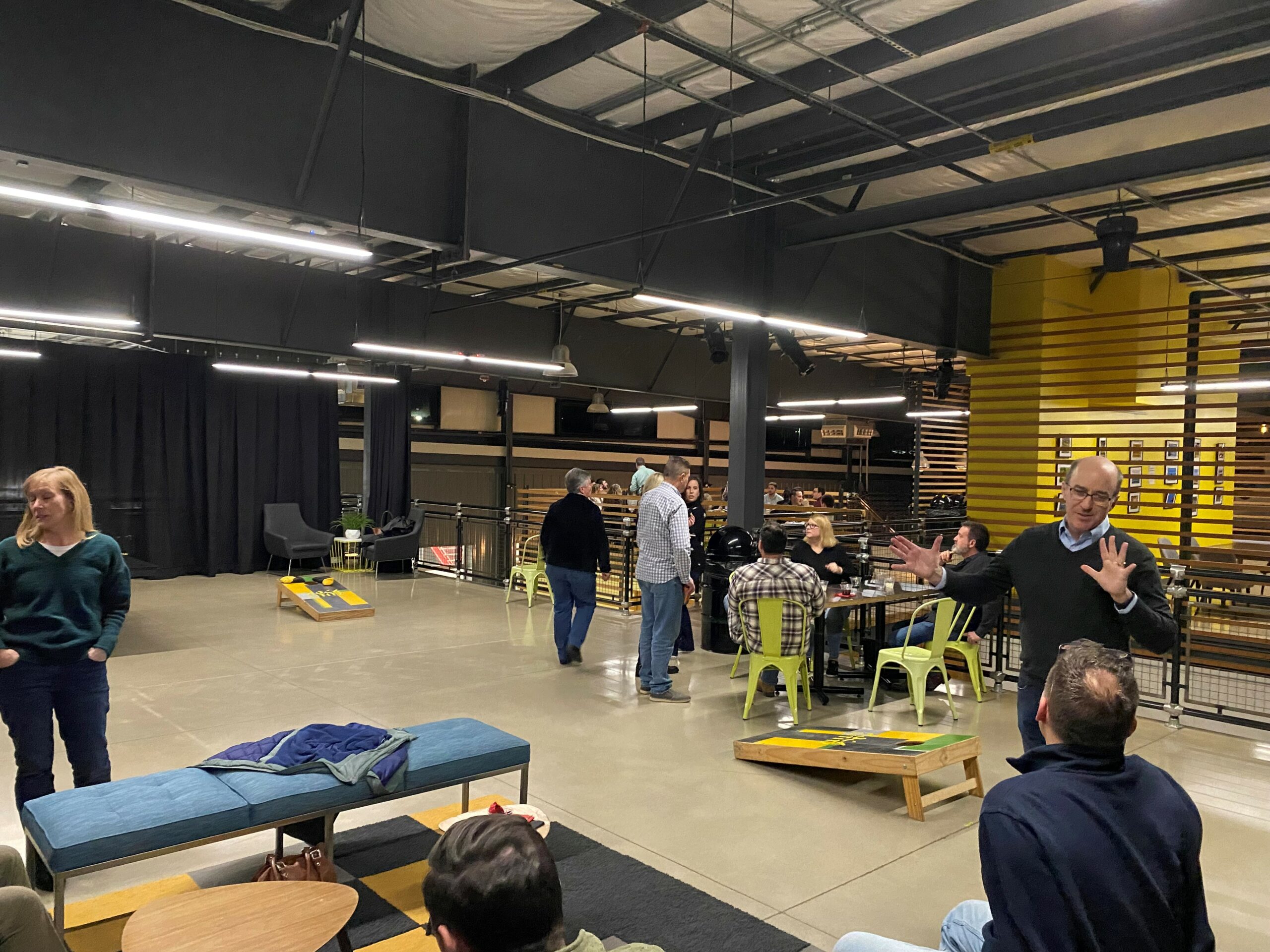 2023 mid-season tax event guests lounging near seating and cornhole