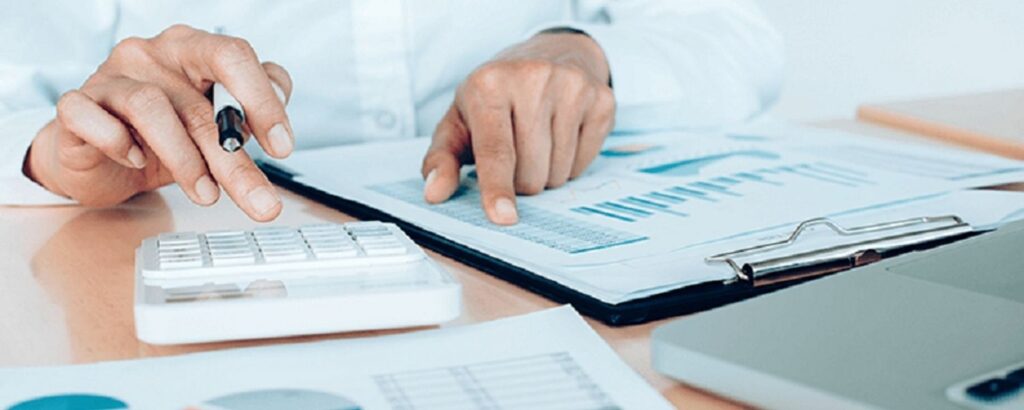 person pointing at a paper and using a calculator